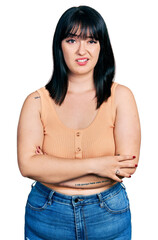 Sticker - Young hispanic plus size woman with arms crossed gesture clueless and confused expression. doubt concept.