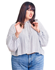 Canvas Print - Young plus size woman wearing casual clothes disgusted expression, displeased and fearful doing disgust face because aversion reaction. with hands raised