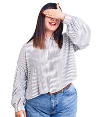 Sticker - Young plus size woman wearing casual clothes smiling and laughing with hand on face covering eyes for surprise. blind concept.