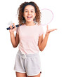 © Krakenimages.com - Beautiful kid girl with curly hair holding badminton racket and shuttlecock celebrating victory with happy smile and winner expression with raised hands