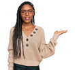 © Krakenimages.com - African american woman wearing casual clothes smiling cheerful presenting and pointing with palm of hand looking at the camera.