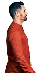 Sticker - Young hispanic man with beard wearing casual shirt looking to side, relax profile pose with natural face and confident smile.