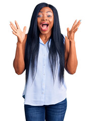 Poster - Young african american woman wearing casual clothes celebrating crazy and amazed for success with arms raised and open eyes screaming excited. winner concept