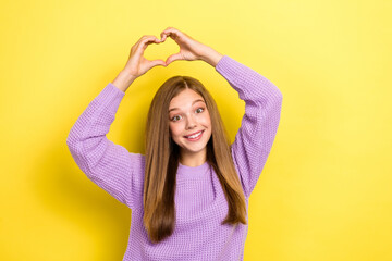 Poster - Photo of cheerful lady wear stylish violet sweater raise arm above head show heart figure empty space isolated on yellow color background