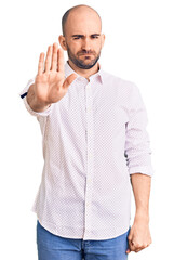 Sticker - Young handsome man wearing elegant shirt doing stop sing with palm of the hand. warning expression with negative and serious gesture on the face.