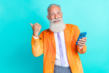 Sticker - Portrait of positive grandfather hold telephone indicate thumb finger empty space isolated on teal color background