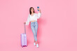 Full size photo of nice young woman suitcase hold smartphone influencer dressed stylish white clothes isolated on pink color background