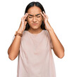 © Krakenimages.com - Young asian woman wearing casual clothes with hand on head for pain in head because stress. suffering migraine.