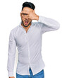 © Krakenimages.com - Young arab man wearing casual clothes peeking in shock covering face and eyes with hand, looking through fingers with embarrassed expression.