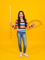 Poster - Back to school. School girl hold ruler measuring isolated on yellow background. Happy teenager, positive and smiling emotions of teen schoolgirl.