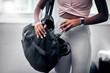 © Mia B/peopleimages.com - Woman, gym and water bottle in bag, hand and hydration at workout, training and fitness class. Black woman, exercise and gym bag for health, self care and wellness with drinking water in Los Angeles