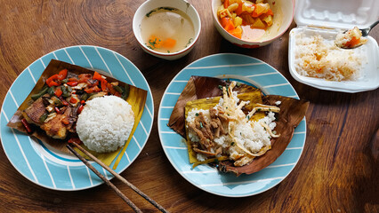 Top view of a table full of authentic traditional khmer food for breakfast of Trei boeng kanh chhet or spicy fried fish and Bai sach chrouk or pork with steamed rice