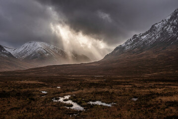 Wall Mural - Majestic dramatic Winter sunset sunbeams over landscape of Lost Valley in Etive Mor in Scottish Highlands