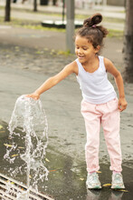 Happy African Girl Playing With Water In The Park Fountain In Summer