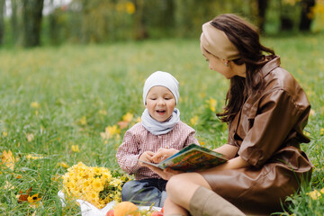 Mom and son walking and having fun together in the autumn park.