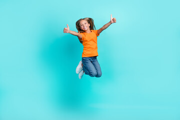 Poster - Full length photo of cute funny active schoolgirl wear orange t-shirt denim jeans showing thumbs up like enjoy isolated on cyan color background