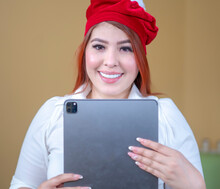 Beautiful Woman Looking At Christmas Shopping On Tablet Wearing A Christmas Hat