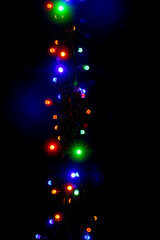 Wall Mural - Christmas and New Year garland with bright multi-colored lights on black isolated background, copy space