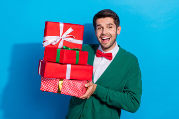 Sticker - Photo of positive excited guy dressed xmas green cardigan rising gifts pile isolated blue color background