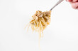 © teine - Spaghetti with smoked mackerel and green peas cream sauce on a white background rolled around a fork