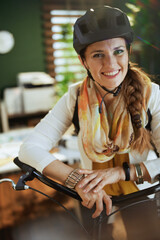 Wall Mural - smiling business woman in bike helmet in eco office