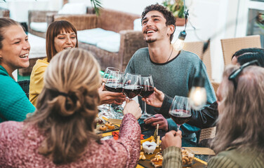 Wall Mural - Happy group of friends clinking red wine glasses at bar restaurant - Group of people enjoying dinner party outside - Dining lifestyle concept