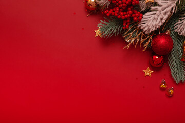 Wall Mural - Christmas decoration and pine tree on red background with copy space. New Year greeting card. Flat lay