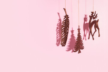 Wall Mural - Christmas New Year tree, deer and feather glitter toys on pink background with copy space