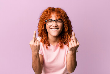 redhair pretty woman feeling provocative, aggressive and obscene, flipping the middle finger, with a rebellious attitude