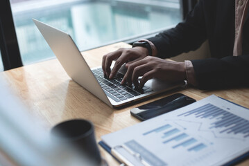 Poster - Businessman working on laptop computer, analyzing business data with paperwork financial report, business document spreadsheet and mobile phone on office table