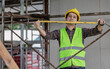 © anut21ng Stock - Asian male builders use tape measures to measure and calculate construction site.