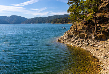 Fishermen in Boat Along The Rocky Shoreline of Pactola Lake, Pennington County, South Dakota, USA