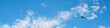 The passenger airplane is flying far away in the blue sky and white clouds. Plane in the air. International passenger air transportation. Banner or header