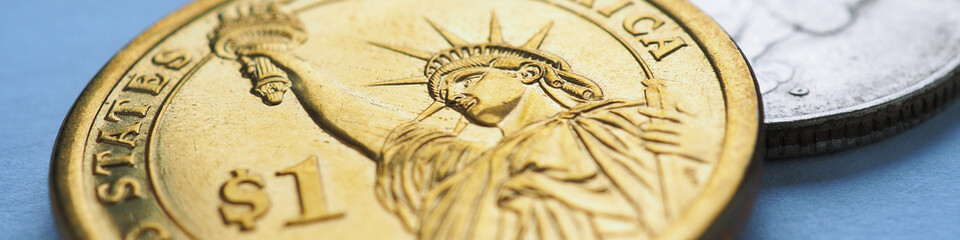 usa coins lie on blue surface. 1 dollar coin close up. statue of liberty. american economy and money