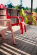 Vertical shot of small colorful chairs on a wooden balcony in sunny weather in Canada