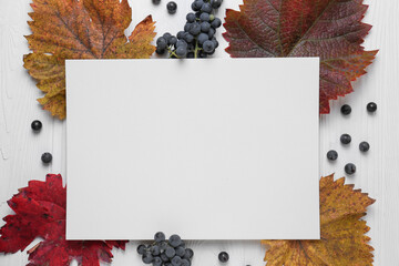 Sticker - Flat lay composition with blank card, autumn leaves and grapes on white wooden table. Space for text