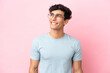 © luismolinero - Young Argentinian man isolated on pink background With glasses with happy expression
