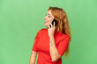 © luismolinero - Young caucasian woman isolated on green screen chroma key background keeping a conversation with the mobile phone with someone