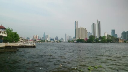 Canvas Print - View of the Chao Phraya River with city buildings in the background. Bangkok, Thailand.