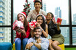 © amorn - Group of happy young man and woman giving Christmas gift box on Christmas party day at night. Merry Christmas and Happy Holidays