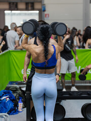 Wall Mural - Girl Doing Exercises with Dumbbells in the Gym: Fitness Workout