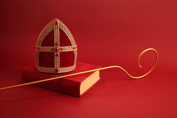 6th december Saint Nicholas Day - Sinterklaas. St Nicholas mitre and book on red table