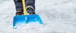 Close-up of a children cleaning and clearing snow in front of the house on a sunny and frosty day. Cleaning the street from snow on a winter day. Snowfall, and a severe snowstorm in winter.