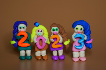 Sticker - Figurines of girls made of plasticine and the figure 2023. A festive event. Calendar date.