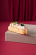 Salted eclair with olives on vinious background. Copy space. vertical. Postcard concept