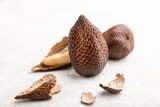 Salak or snake fruit on gray concrete background. Side view, close up, selective focus.