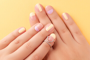 Wall Mural - Beautiful females hands with manicure on yellow background. Trendy minimal spring summer nail design