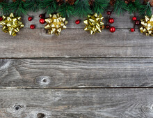 Merry Christmas Or Happy New Year Background With Fir Tip Tree Branches And Gold Bows On Rustic Wood