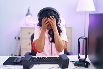 Poster - Mature hispanic woman playing video games at home with sad expression covering face with hands while crying. depression concept.