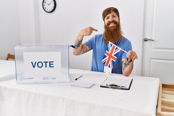 Wall Mural - Caucasian man with long beard at political campaign election holding uk flag pointing finger to one self smiling happy and proud